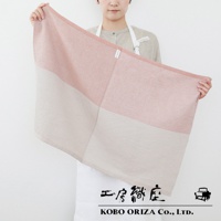 一位女子手持一條粉色與米色拼接的 WAFLE 棉麻混紡拭巾，拭巾有著鬆餅般的立體紋理，左側印有 KOBO ORIZA Co., LTD. 字樣。