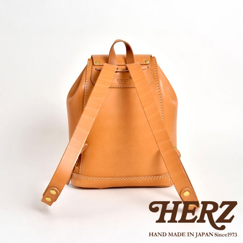 職人手作皮革經典後背包，呈現自然原色皮革，帶有精緻縫線與金屬釦細節，設計簡約實用。