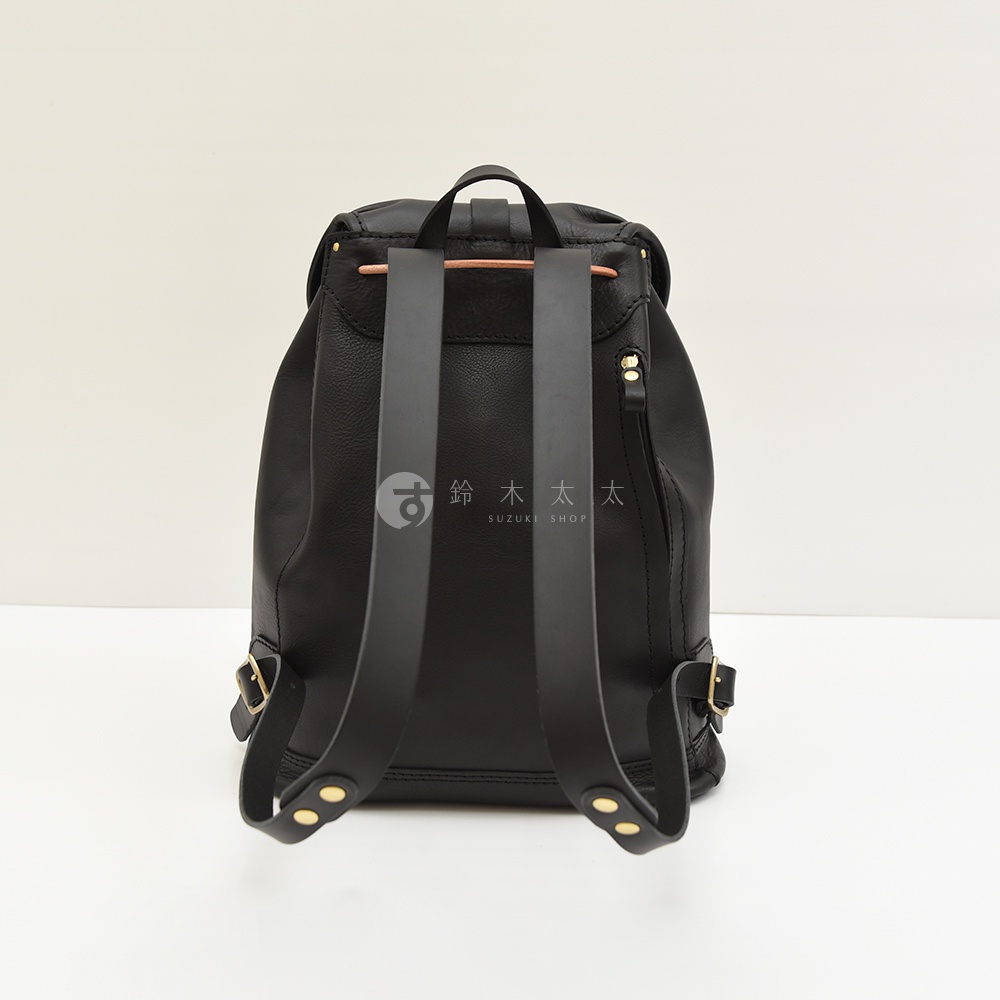 黑色皮革單扣束口後背包，配有可調節的肩帶和金色金屬配件。