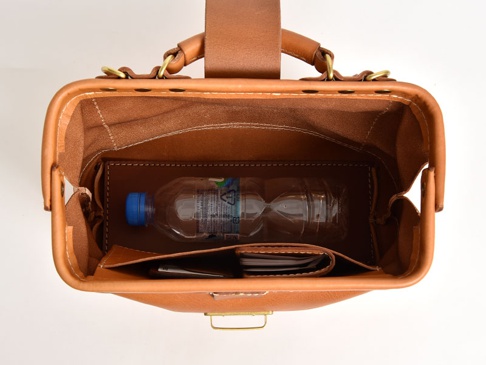 職人手作皮革兩用迷你口金單肩包 (CW-7)，棕色皮革製成，包內有手機、卡夾與寶特瓶。