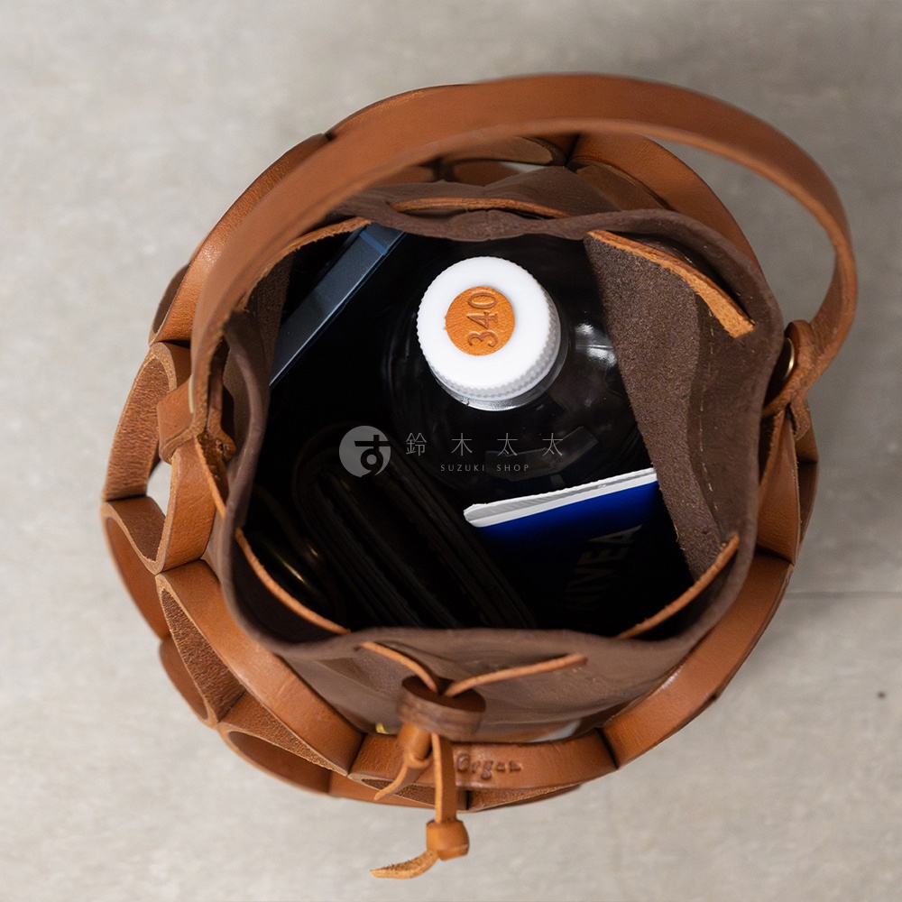 日本HERZ Organ編織水桶包，裝有水瓶、手機和錢包，頂部視角。