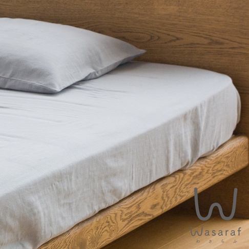 淺灰色雙人床包和枕套，採用二層紗和晒材質，鋪在木質床架上。