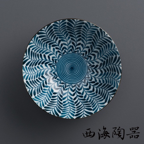 一個陶瓷粥碗，碗內繪有深藍色、放射狀的樹葉或羽毛紋飾，中央為藍色螺旋紋。碗緣有細緻的金邊。