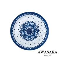 一個白底藍花的歐風淺湯盤，中央有放射狀的藍色花紋，周圍點綴著白色小點，外圈有藍色波浪狀邊緣。