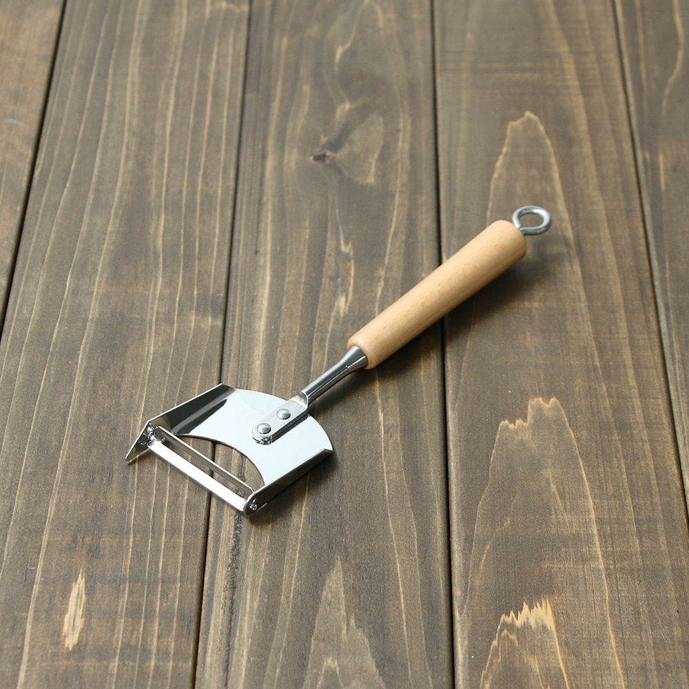 VEGET 不鏽鋼木柄削皮刀，具有光滑的木質手柄和銀色不鏽鋼刀頭，刀頭呈扇形，設有可替換的刀片，手柄末端有掛環。