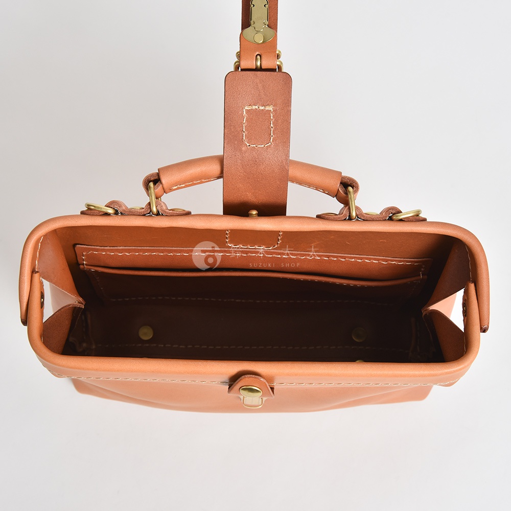 職人手作皮革迷你軟皮包，頂部視角，展現棕色皮革材質、雙提把、內部隔層及金色金屬扣。