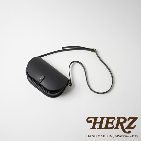 黑色皮革迷你馬鞍包，附有可調節肩帶和金屬扣。