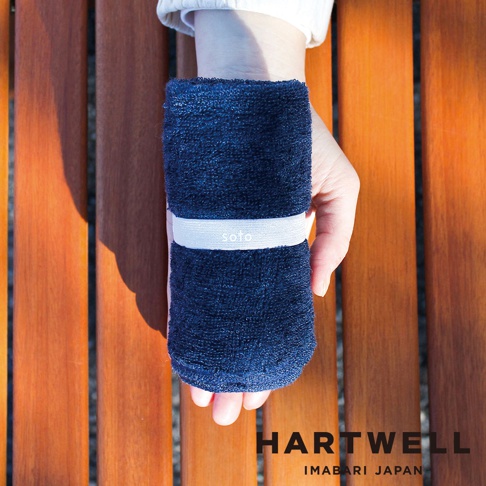 深藍色毛巾纏繞在手腕上，中間有一條淺色束帶，束帶上印有 soto 字樣。