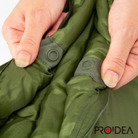 雙手正在操作一個軍綠色、尼龍材質的兩用睡袋，展示其內部的按扣和拉鍊設計。