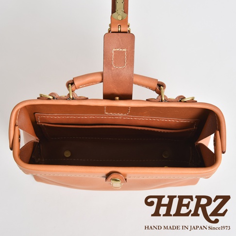 職人手作皮革迷你軟皮杜勒斯包，採用天然棕色皮革製成，頂部有提把和皮帶扣，內部有夾層和金色金屬扣。