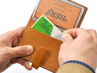 職人手作皮革卡片收納夾，淺棕色牛皮材質，夾內有一張綠色日文卡片，上方為透明夾層，可收納多張卡片。