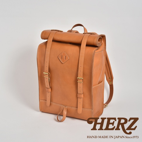 職人手作皮革露營登山用大容量後背包 R-19，採用溫暖的棕褐色皮革，設計簡約，配有可調節的肩帶、捲口設計和金屬扣環，展現經典復古風格。