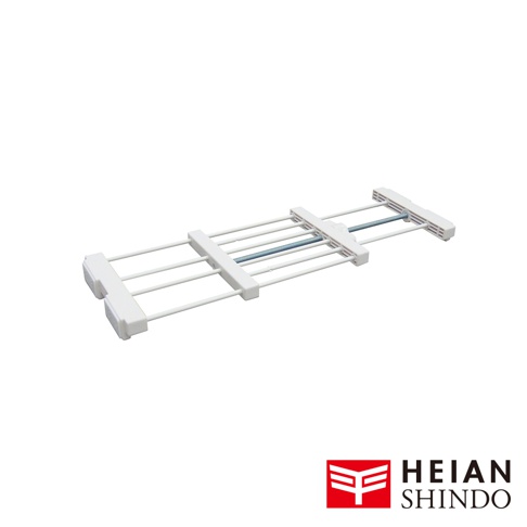 一個由白色管狀金屬和塑料組件構成的伸縮式置物架，中間有一根藍灰色的金屬桿，下方有平安伸銅的紅色標誌。