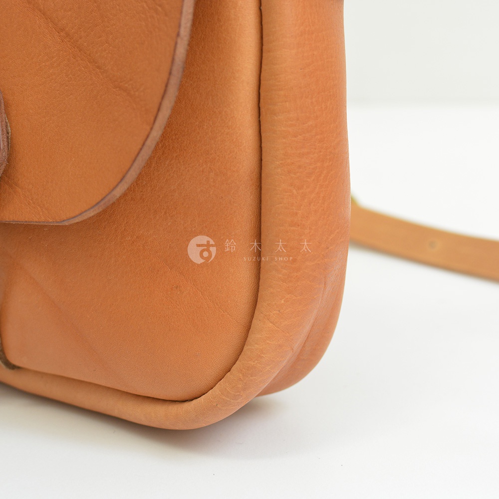 職人手作皮革鹿角扣繩肩背包，淺棕色，皮革材質，呈現自然紋理。