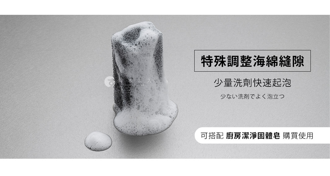 深灰色超細纖維清潔海綿，表面覆蓋豐富的白色泡沫，一旁有少量泡沫滴落。