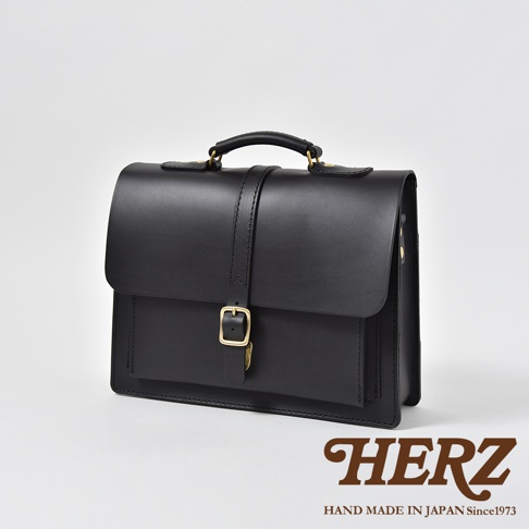 職人手作黑色皮革商務後背包，配有單扣及頂部提把，簡約設計，適合商務場合。