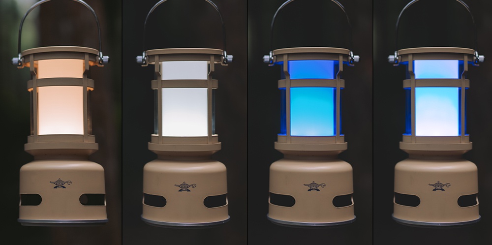 四個神燈音箱並排展示，皆為米色塑膠材質，頂部有金屬提把。第一個音箱發出橘色光，第二個發出白色光，第三個和第四個發出藍色光。