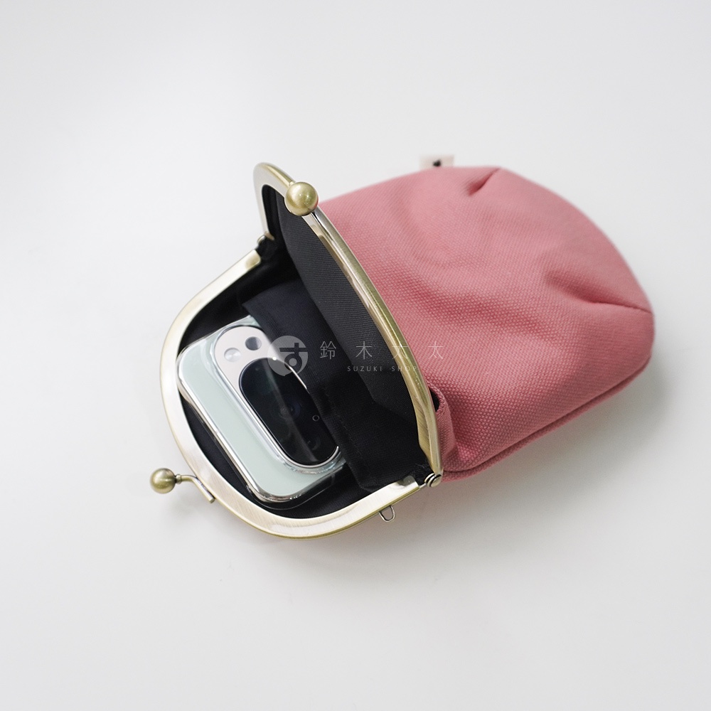 紅色帆布腰掛口金包內放著一台手機