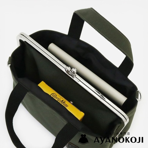 一綠色帆布口金手提包，內有一黃色條狀物和一白色長條物。