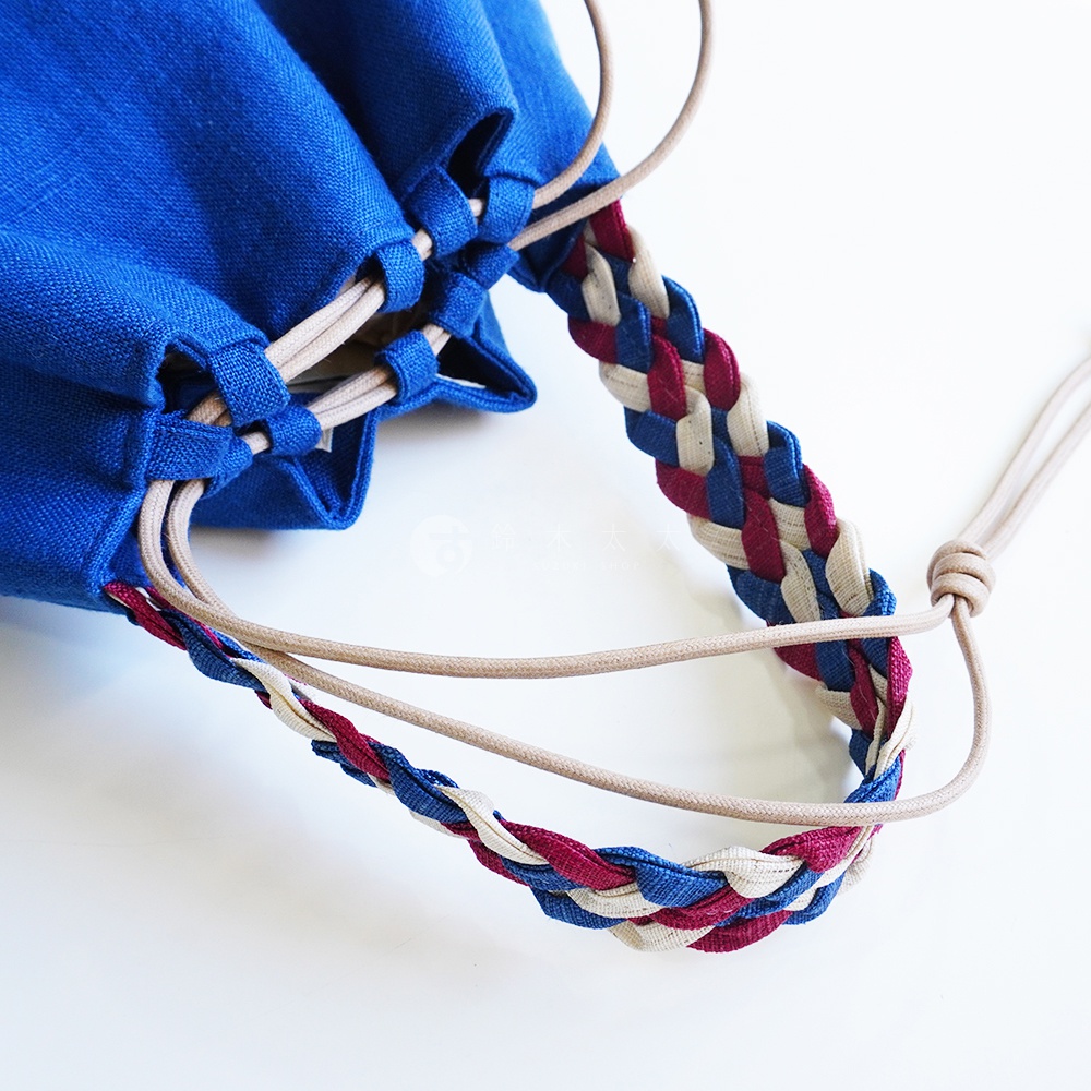 BAN INOUE 麻花辮束口手提包，藍色織物束口袋搭配條紋編織提把，細節精緻。