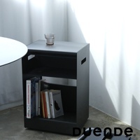 一個黑色金屬收納推車，上面放著一杯水，下方層架上擺放著幾本書。