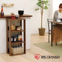 深棕色木質四層收納架，展示有罐頭、麵食、調味料及編織籃，架子置於廚房檯面下方，旁邊有綠植及用餐區。