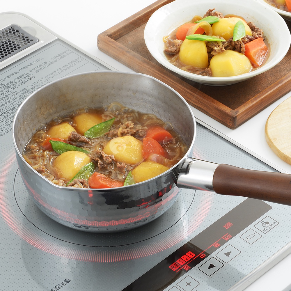 鄉技不鏽鋼單柄雪平鍋，鍋內盛有燉煮的牛肉、馬鈴薯、紅蘿蔔及豌豆，鍋身為銀色不鏽鋼材質，帶有錘紋，握把為深棕色木質。