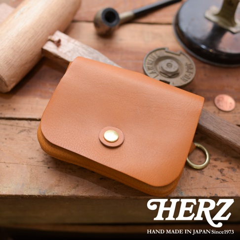 職人手作皮革旅行用雙層錢包，採用皮革材質，設有金色按鈕開合，並配有金屬環，整體呈棕褐色。