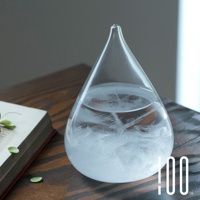 一個透明的玻璃製成，水滴狀的Tempo Drop天氣瓶，瓶內裝有液體，底部和中部有細緻的白色結晶，瓶口細長。