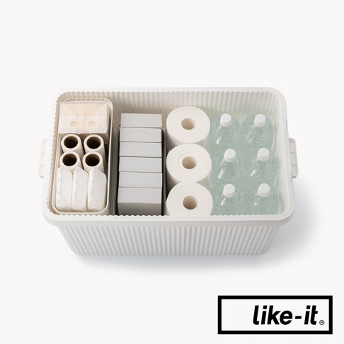 白色可疊式波浪紋收納箱，內部裝有小型收納盒，收納盒內有捲狀物體、薄片狀物體和瓶裝水。