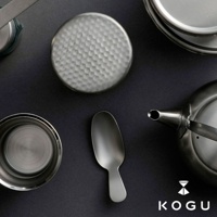 日製18-8不鏽鋼茶葉罐，罐蓋有錘目紋，搭配同材質茶匙，整體呈現銀色金屬光澤。