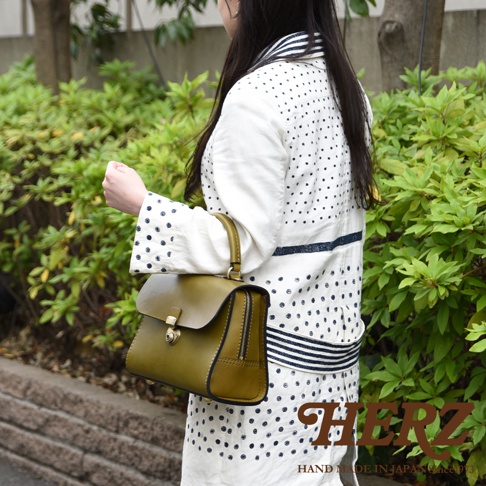 日本HERZ品牌，職人手作橄欖綠色皮革多功能收納單肩包，搭配白色圓點圖案服飾