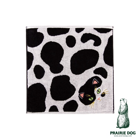 一張 Prairie Dog 品牌的今治細柔貓感刺繡方巾，方形巾面為黑白斑點設計，右下角巧妙隱藏著一隻探出頭的貓咪刺繡，搭配綠色眼睛與細緻的鬍鬚細節，右下角標示著 Prairie Dog 品牌名稱及網址。