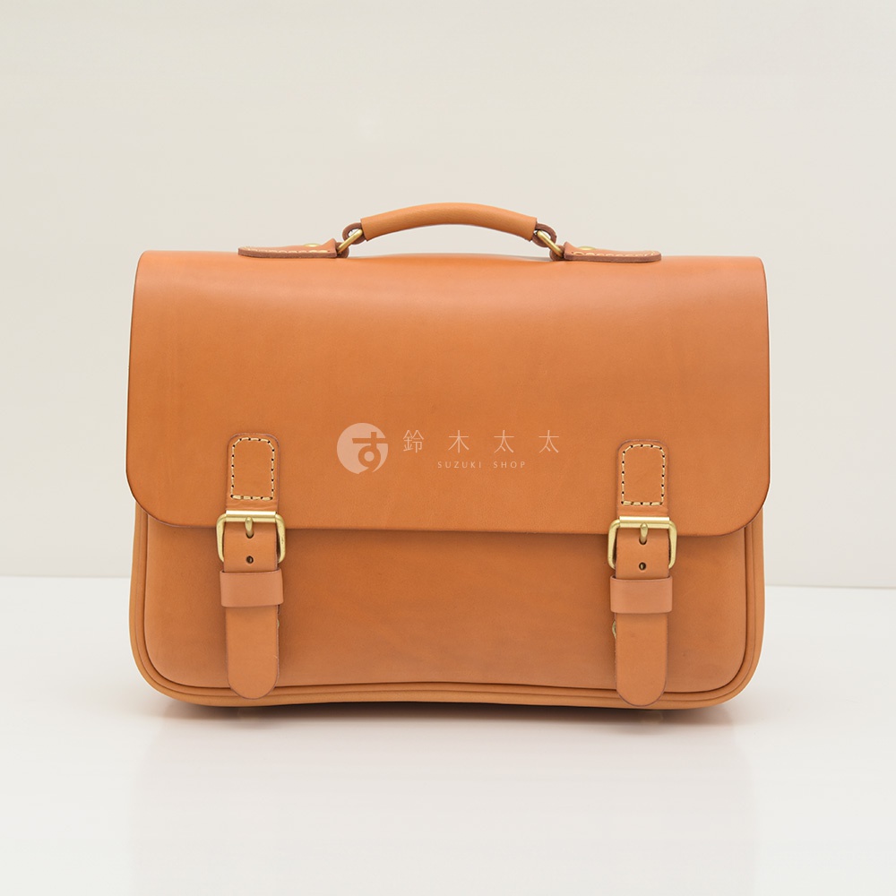 職人手作皮革極簡風三用商務公事包，焦糖色牛皮材質，設有頂部提把、雙皮帶釦翻蓋設計，可肩背或側背。