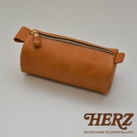 職人手作皮革多用途收納筆袋 KP-146，焦糖棕色。此款筆袋由天然皮革製成，圓柱形設計，配有金屬拉鍊和皮革拉環，品牌標誌壓印在皮革小標籤上。