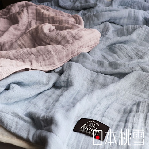五層紗透氣單人被，有粉色和藍色兩種顏色，其中藍色被子上有hiorie品牌標籤，標籤上印有MADE IN JAPAN字樣，下方有日本桃雪字樣。