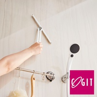 白色可折疊刮水器，帶有銀色轉軸，由人手握持，正在清潔有水漬的淺色牆壁。右側有白色淋浴噴頭和粉紅色品牌標誌。