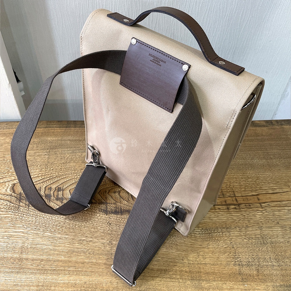 犬印純綿帆布三用直式側背包，米白色帆布包身，搭配咖啡色皮革提把與品牌標籤，深棕色寬版織帶可調整長度，銀色金屬扣環。