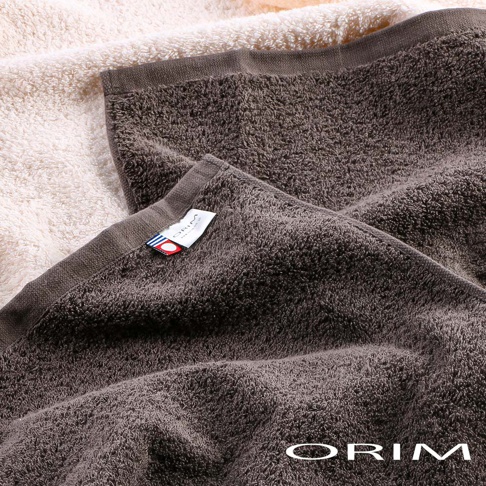 兩條 BULKY PRO 今治沙龍浴巾，一條為深棕色，另一條為米白色。深棕色浴巾上有 ORIM 品牌標籤。