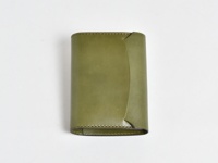 橄欖綠皮革A6記事本書套，表面平整，邊緣縫線細緻，一側邊緣有弧形設計。