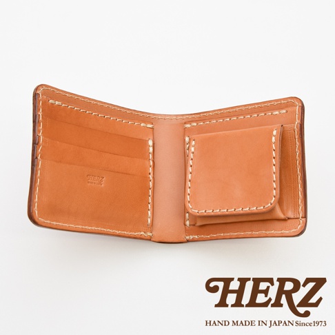 職人手作皮革經典雙折短夾，展示其打開的狀態，露出淺棕色皮革內裡，有卡槽及零錢袋，縫線清晰。