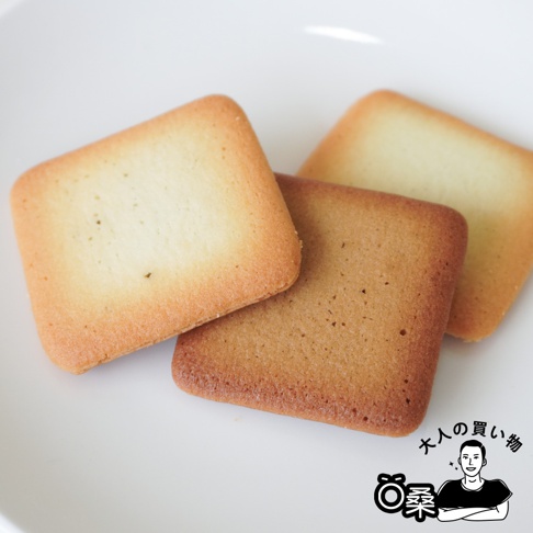 三塊方形的餅乾，其中兩塊疊放，上面一塊顏色較淺，下面一塊顏色較深，還有一塊淺色餅乾在最上面，疊放的餅乾右側。