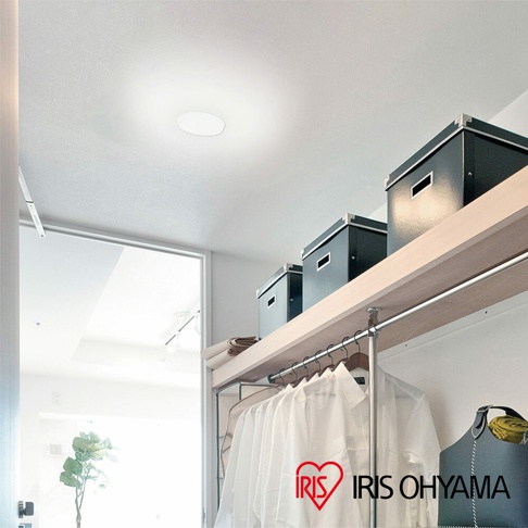 SCL20 LED小型吸頂燈，圓形白色燈罩，安裝於白色天花板上，下方為木質層架，擺放黑色收納盒，並懸掛多件白色衣物。