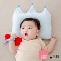 淺藍色皇冠造型嬰兒枕，枕頂有兩個藍色絨球裝飾，由柔軟布料製成，適合7至24個月嬰兒使用。