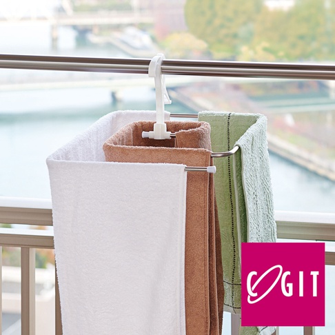 白色塑料卡扣式通風晾曬架，懸掛著三條毛巾，分別為白色、棕褐色和淺綠色，架身為銀色金屬材質。