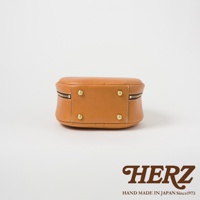 HERZ 職人手作皮革兩用圓形包 Q-13，駝色，底部有四顆金屬腳釘，側邊有拉鍊。