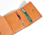 職人手作皮革三折式迷你短夾，淺棕色皮革，內有兩張卡片，一張為綠色VISA卡，另一張為星巴克禮品卡，縫線清晰，設有銅製按扣。