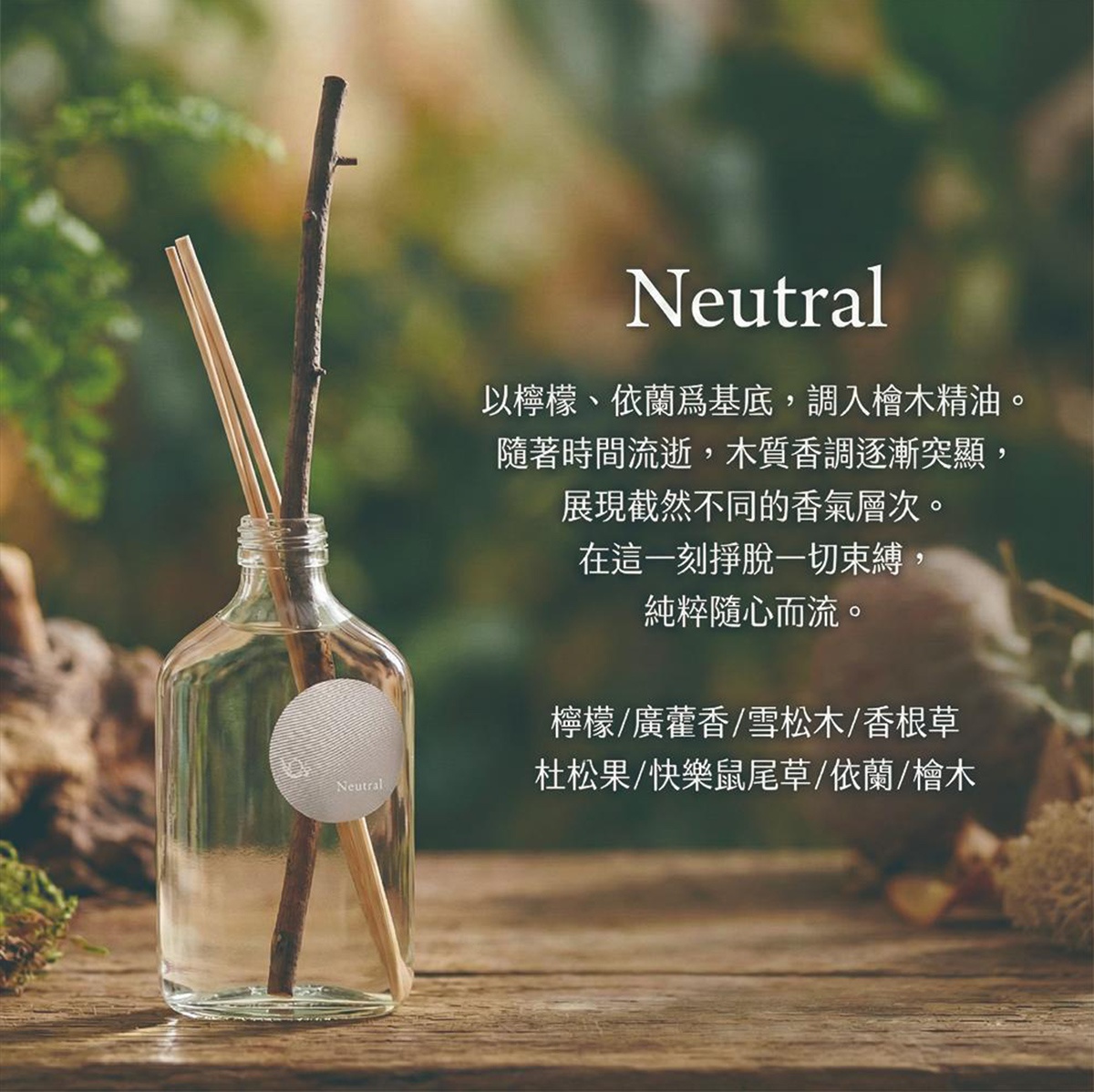 Neutral 擴香瓶內有兩根檜木擴香棒，瓶身貼有圓形標籤，背景為模糊的綠葉與木紋。