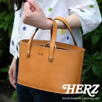 棕色皮革束口手提包，有著雙提把和精緻的縫線，包身正面有品牌壓紋。