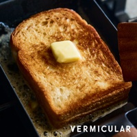 琺瑯鑄鐵玉子燒平底鍋，鍋內煎著一片金黃酥脆的吐司，上面融化著一塊奶油，鍋底有融化的奶油和泡沫。